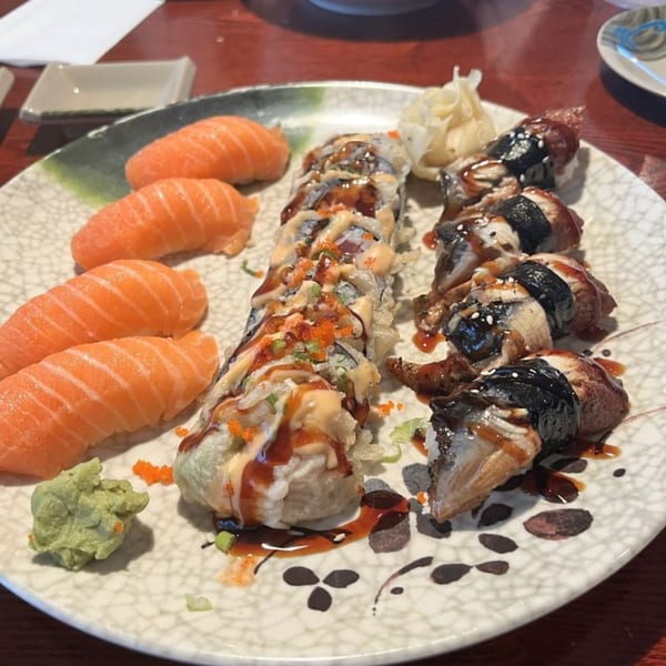 A plate of Ginbu 401 sushi with salmon nigiri, dragon roll, and spicy tuna roll.